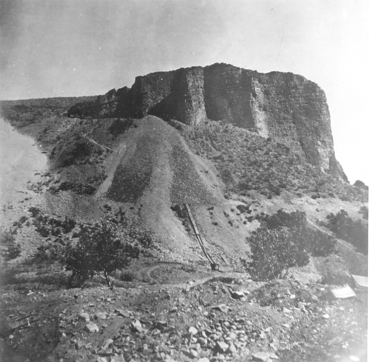 Black and white photo of penstocks on side of the hill