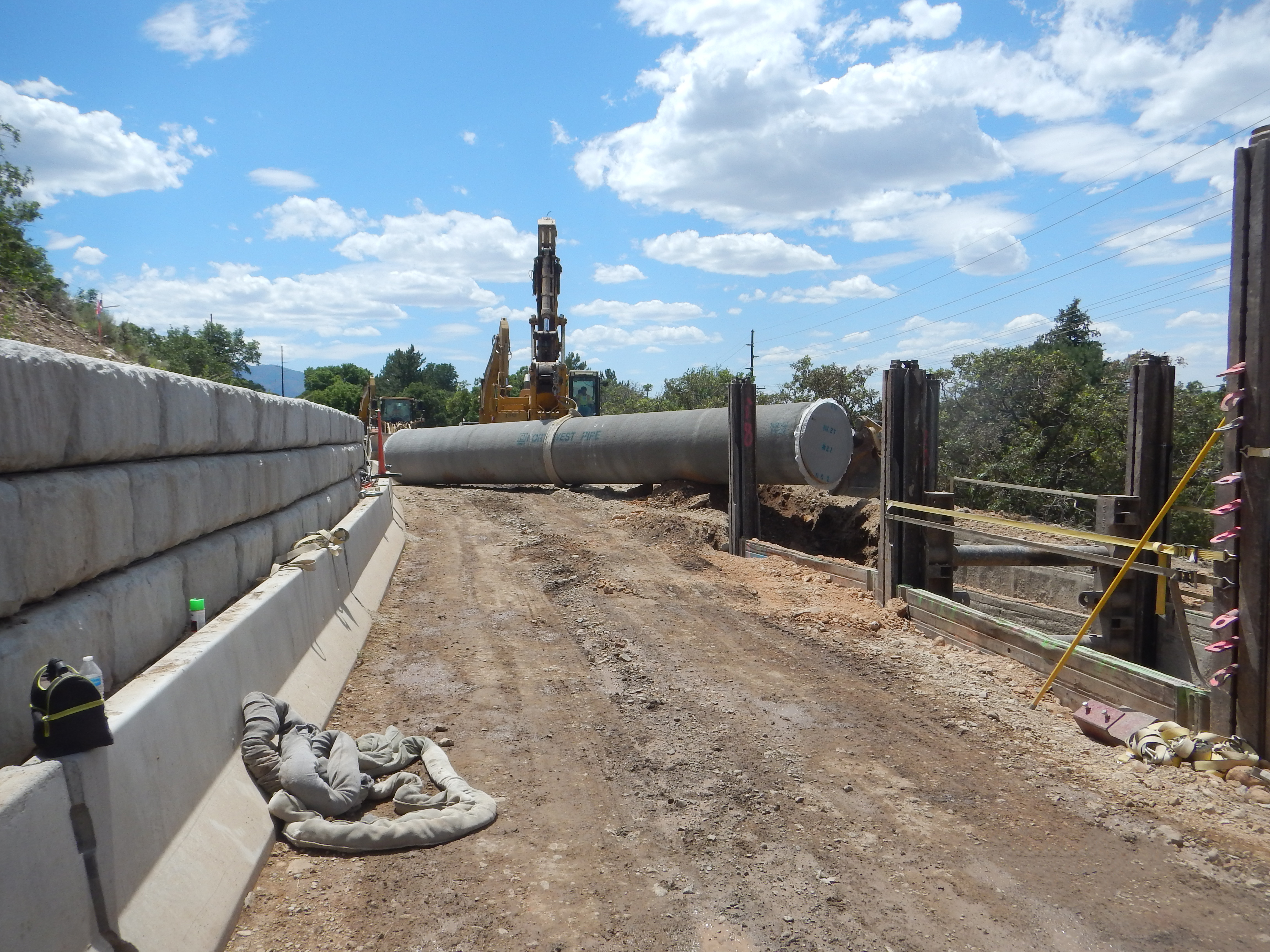 Pipeline being moved my construction equipment into a trench